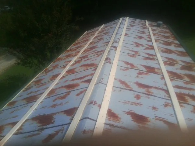 Rusted metal roof panels with new wood purlins before replacement — Storm Damage Roof Repair in Cedar Lake by Roofing Brothers