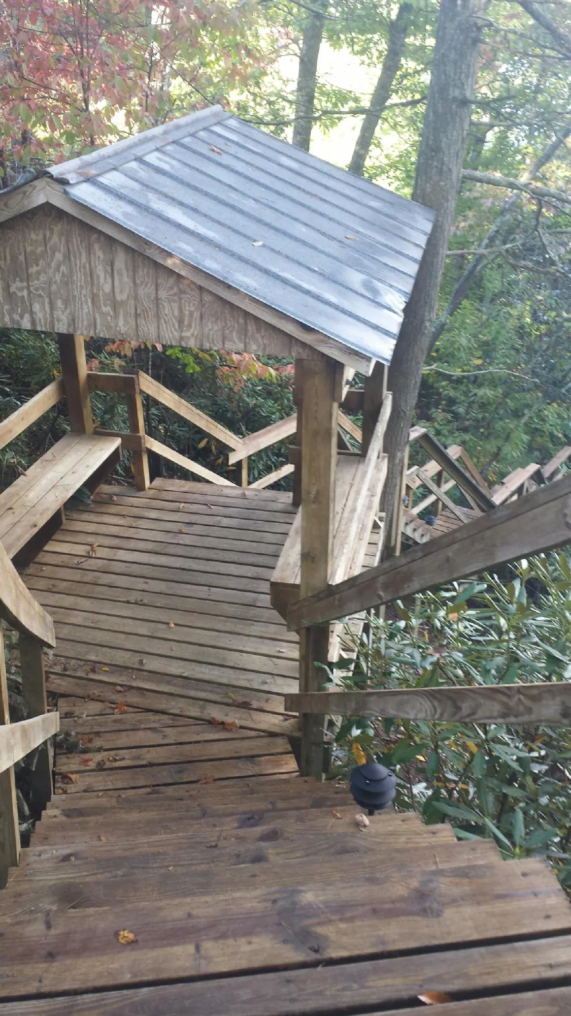 Metal roofed shelter over wooden steps on a wooded walkway — Skylight Repair & Installation work by our crew in Cedar Lake